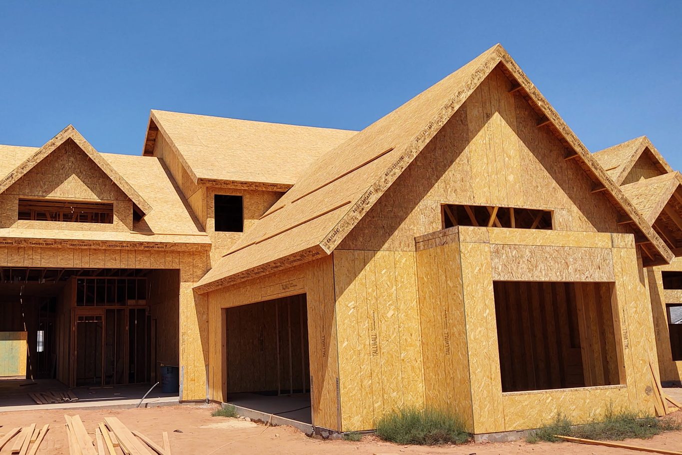 Framed home with several roof gables, a garage opening and a large window opening